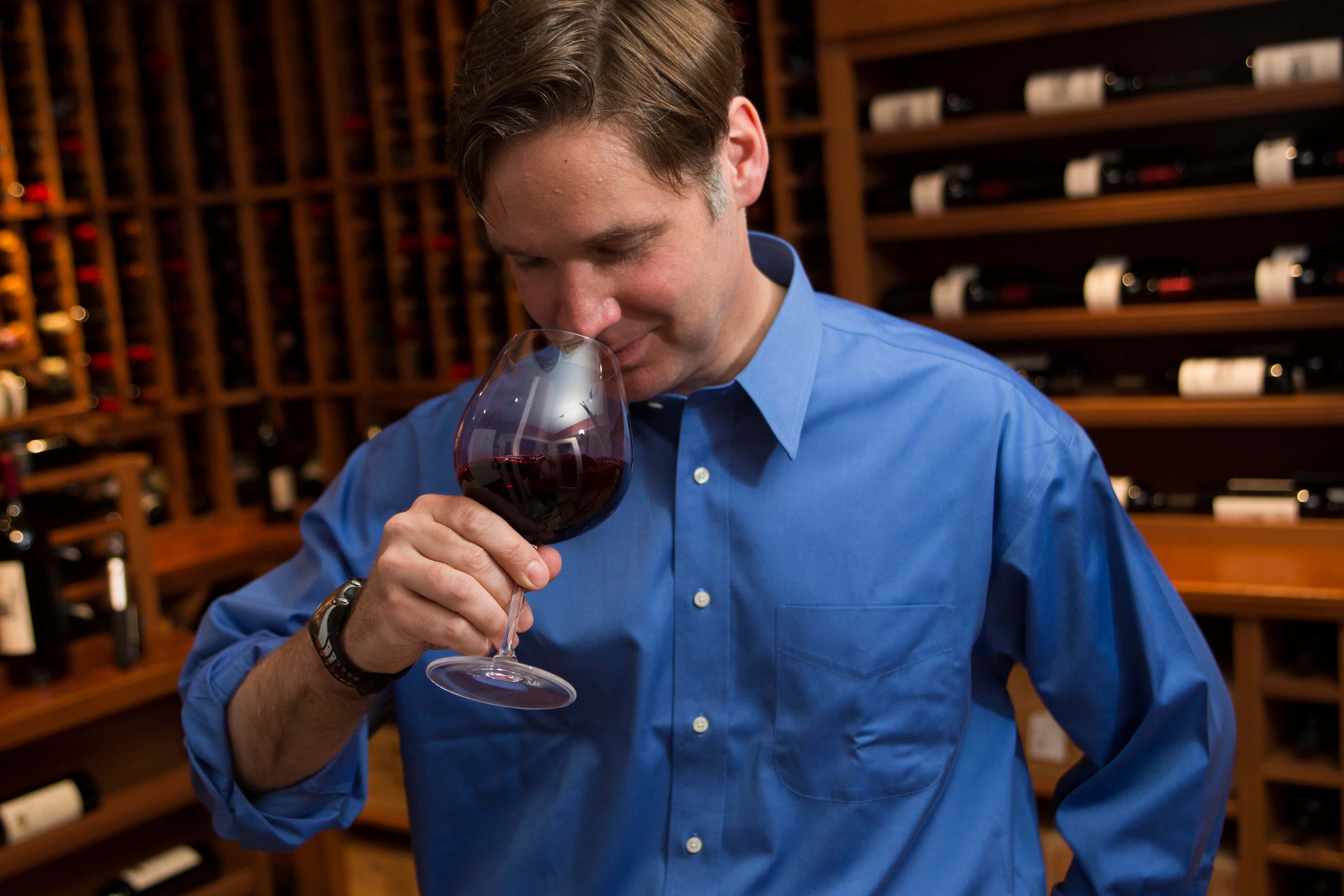 A man smelling a glass of wine