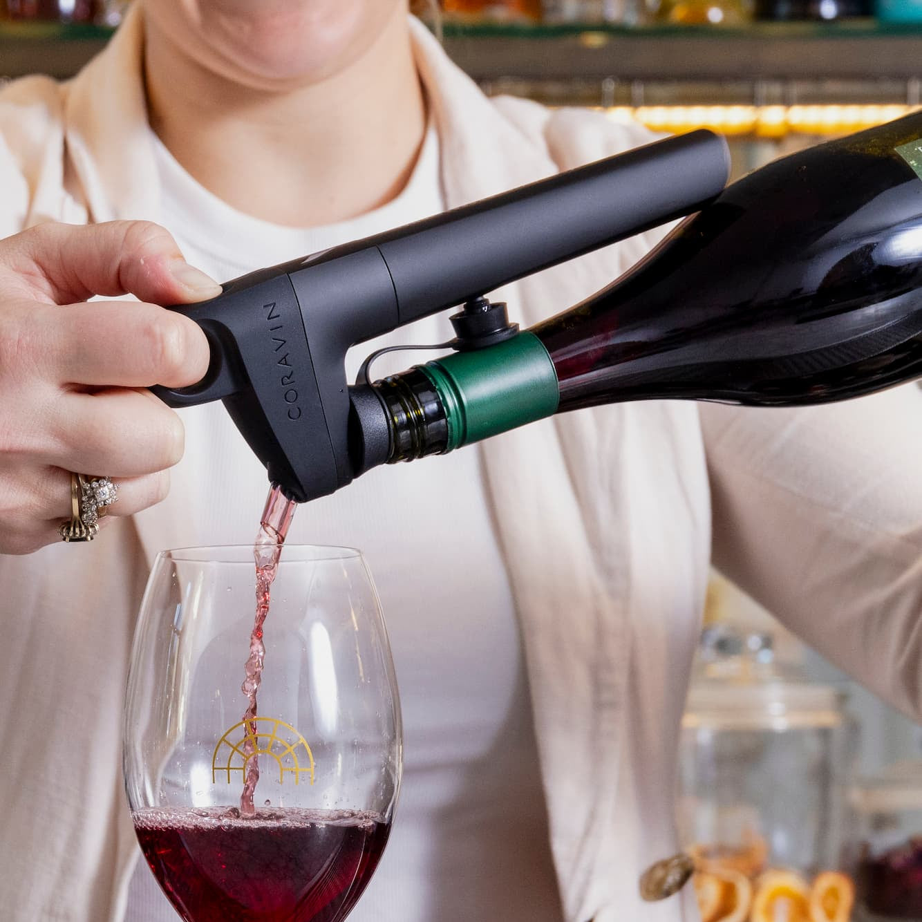 a person using a Coravin Pivot+ wine dispensing system