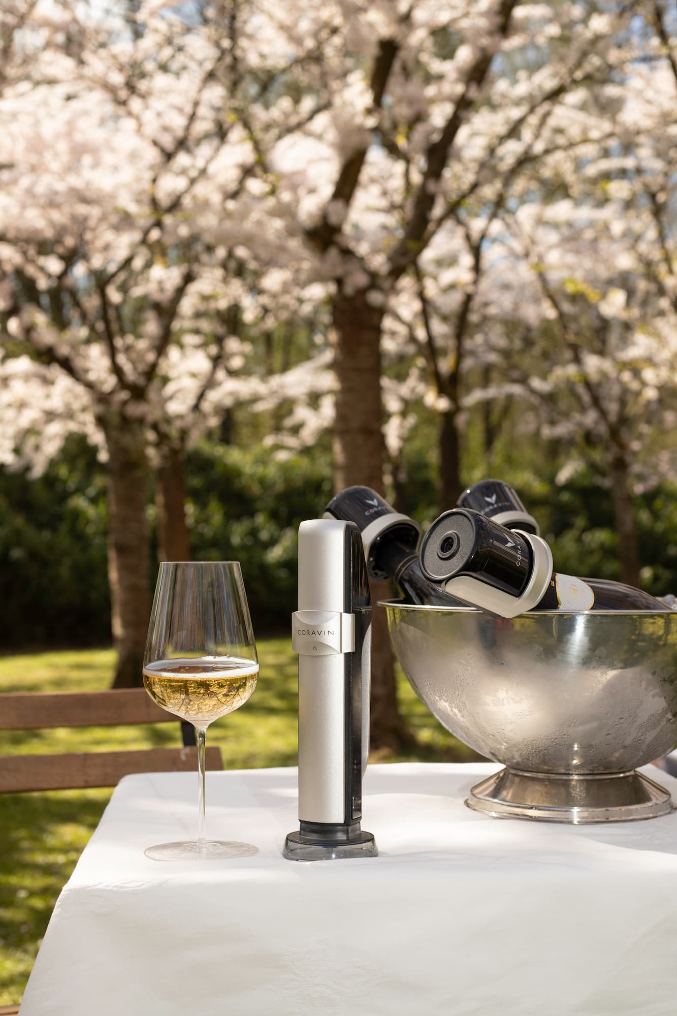 sparkling wine glass, Coravin sparkling stopper and a bowl of wine bottles with Coravin stoppers