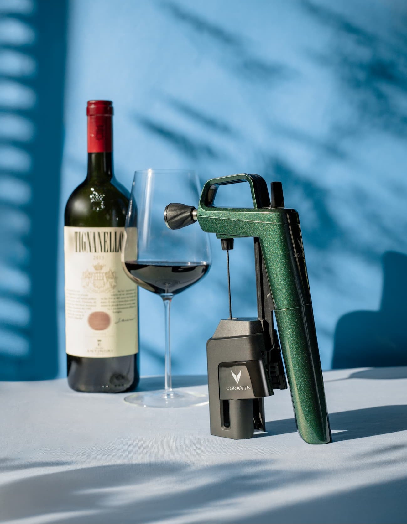 red wine bottle, filled glass, and Coravin wine-by-the-glass system, showcasing top wine preservation system